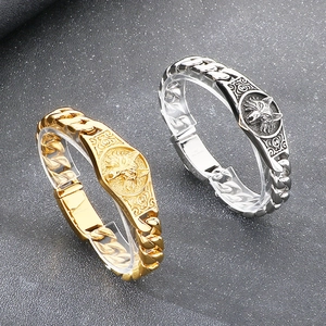 Detail of 316L stainless steel Cuban link bracelets with gold and silver wolf medals