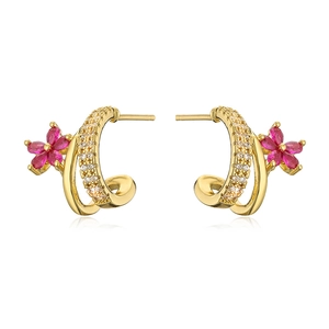 Detailed macro view of 18K gold plated C-shaped earrings with magenta floral gemstone accents