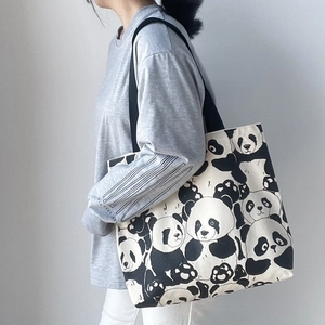Detailed view of cute panda canvas tote bag worn over the shoulder by a model