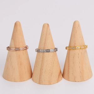 Elegant geometric pavé eternity rings in rose, white, and yellow gold on wood stands