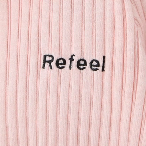 Détail du tricot côtelé rose avec broderie Refeel sur le revers du pull élégant