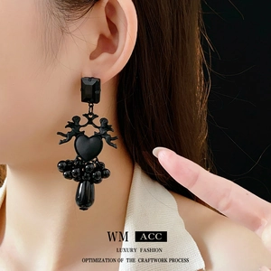 Silver needle angel heart earrings with black beads and teardrop pendant on model