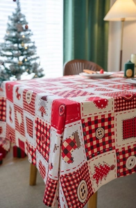 Detail of buffalo plaid Christmas tablecloth with festive tree and stocking patterns