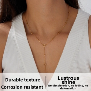 Detail of gold-plated stainless steel Y-shaped necklace with flower charms on a model