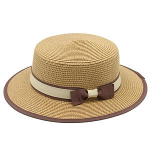 Classic straw boater hat for women with cream ribbon and brown bow detail for beach wear