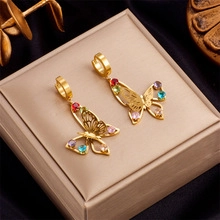 Macro shot of gold butterfly earrings with colorful rhinestones on a jewelry box