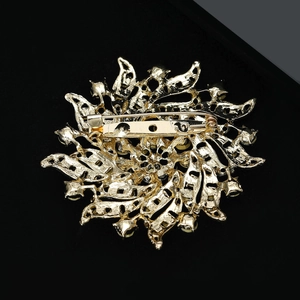 Détail du mécanisme d'épingle sur le revers d'une broche fleur dorée en strass