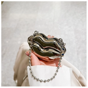 Close-up of a lip-shaped silver metal mini bag with bead chain strap for fashion