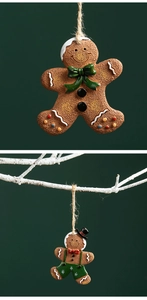 Detailed view of resin gingerbread man ornaments with jute ropes on festive green backdrop