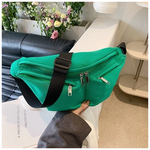 Close-up of bright green nylon crossbody bag with multi-pockets and adjustable strap