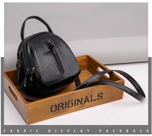 Close-up of black PU leather texture and zipper detail on a fashion crossbody bag
