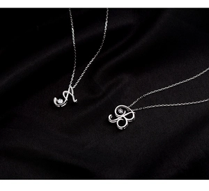 Close-up of 925 silver alphabet necklace pendants with sparkling cubic zirconia