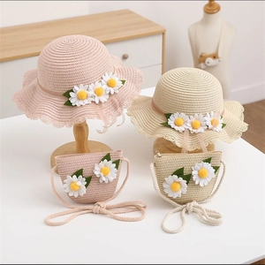 Detail of hand-woven straw hats and matching crossbody bags with daisy accents