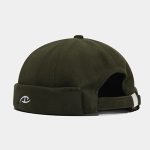Close-up of olive green docker hat featuring white embroidered logo and cotton twill texture