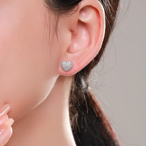 S925 sterling silver heart stud earrings with micro-pave crystals on a model's ear
