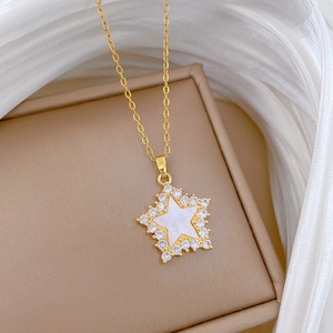 Gold star necklace with white shell inlay and zircon accents on jewelry box