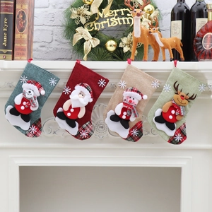 Detail of four fabric Christmas stockings with 3D Santa, Snowman, Reindeer, and Bear dolls