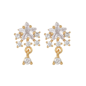 Detalle macro de pendientes de estrella con baño de oro y brillantes piedras de circón