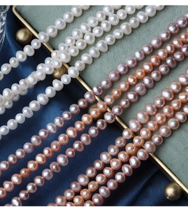Macro shot of 5mm natural freshwater pearls in white pink and purple on velvet