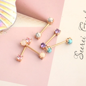 Macro view of rose gold barbell piercings with five different heart-shaped zircon stones