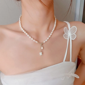 Detail of freshwater pearl necklace with lily of the valley flower pendant on model