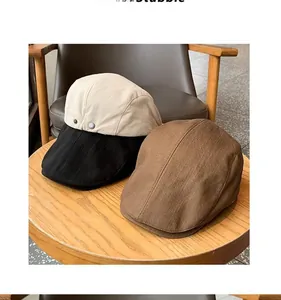 Close-up of retro newsboy caps in beige, black and brown on a vintage wooden table
