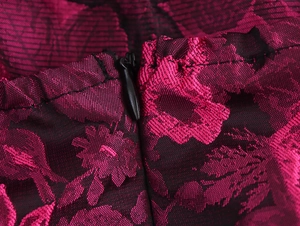 Macro shot of magenta floral jacquard fabric with a concealed black zipper detail