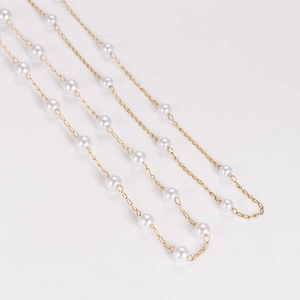 Elegant golden stainless steel chain necklace with irregular white pearls on a white background