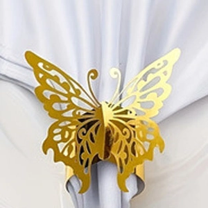 Detailed close-up of golden hollow butterfly napkin ring on a white fabric napkin