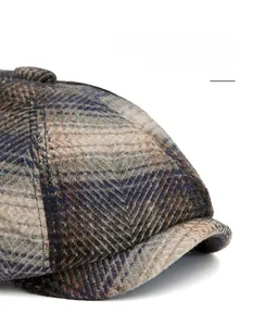 Détail de la casquette gavroche en tweed montrant la visière large et pliable