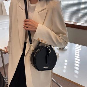 Fashionable round black leather crossbody bag with gold zipper and handle for women