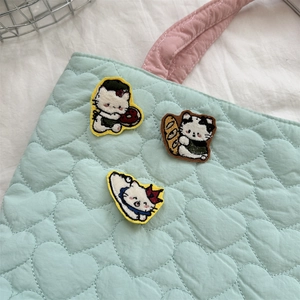 Detailed embroidery of cartoon cat patches on a quilted heart handbag mint green bag