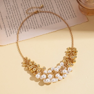 Vintage baroque golden necklace with cluster pearl pendant over a retro paper background