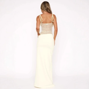 Detail of white lace bodysuit back design with thin straps and floor-length skirt
