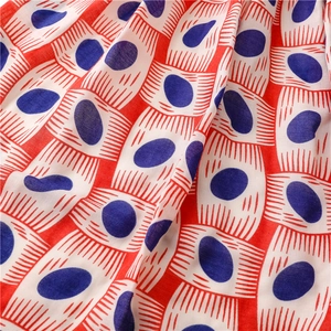 Macro shot of blue oval and red line patterns on soft cotton blend scarf fabric