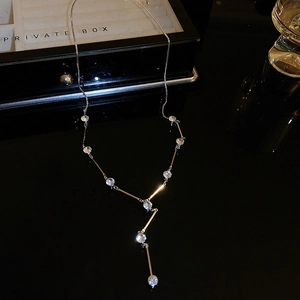 Detailed view of silver Y-shaped tassel necklace with sparkling rhinestones and metal bars