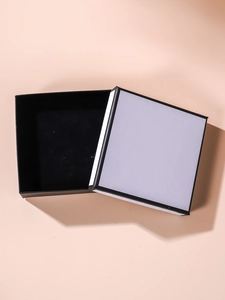 Detail of square black and white jewelry box with soft black velvet padding insert