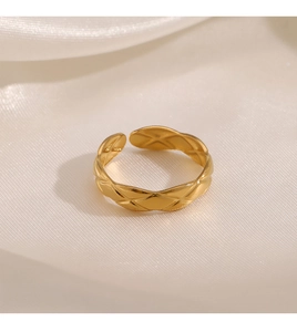 Detail of gold quilted geometric ring showing the textured surface on silk background