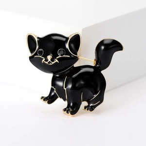Close-up of black enamel cat brooch with gold metal edges and rhinestone eyes detail