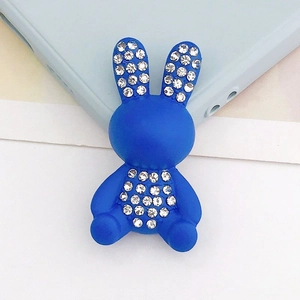 Dettaglio di un ciondolo a coniglio blu con strass per cover di telefoni e accessori