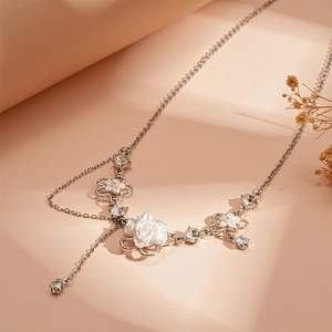Dettaglio ravvicinato di una collana a fiore argento con petali bianchi e perle eleganti