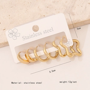 Macro shot of 4 pairs of gold stainless steel hoop earrings on white display card