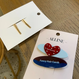 Gros plan de barrettes dorées et pince cœur en strass sur une surface en bois