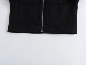 Détail d'une veste courte en tweed avec fermeture éclair et poches carrées