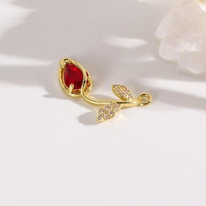 Detailed view of golden tulip flower connector with red stone and pavé zircons