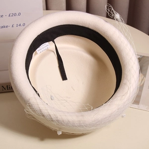 Detail view of the 100% wool beige French beret with soft mesh veil and plush polka dots