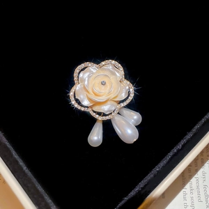 Vue détaillée d'une broche florale élégante avec des cristaux et des perles en boîte cadeau
