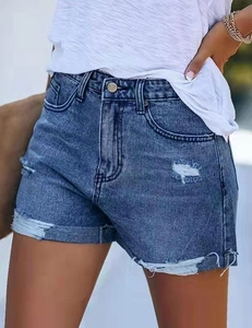 Gros plan d'un short en jean avec des déchirures, une texture usée et des ourlets effilochés