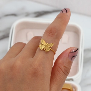 Detail of 18K gold butterfly ring with twisted band on a woman's finger