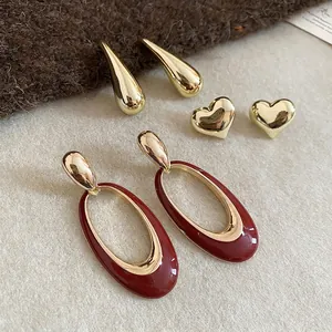 Three-piece gold earring set featuring heart, teardrop, and burgundy enamel oval designs